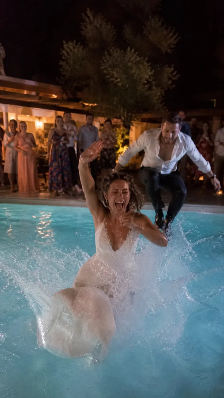 Mariés qui sautent dans la piscine pendant la soirée de mariage